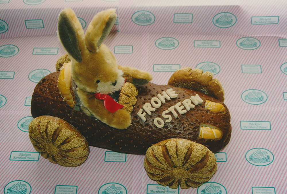 Ein Osterhase, der in einem Fahrzeug aus Gebäck sitzt.